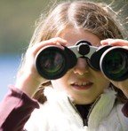 Young girl looking through binoculars